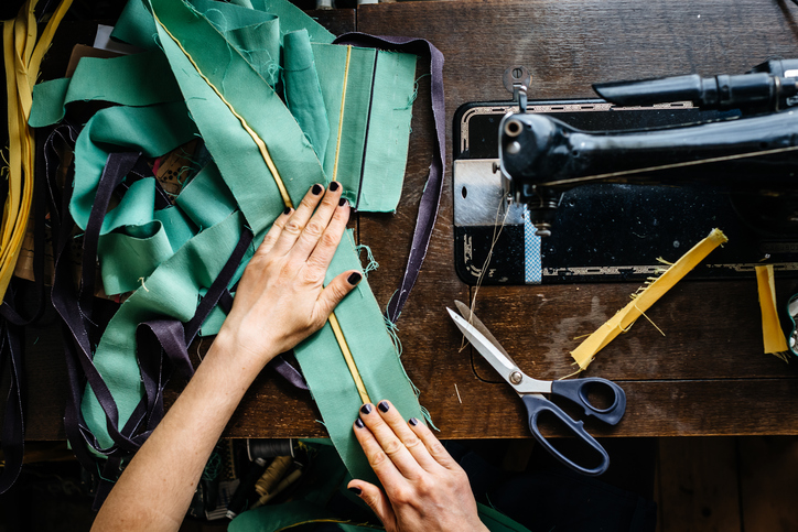 Hands of a woman sewing fabrics